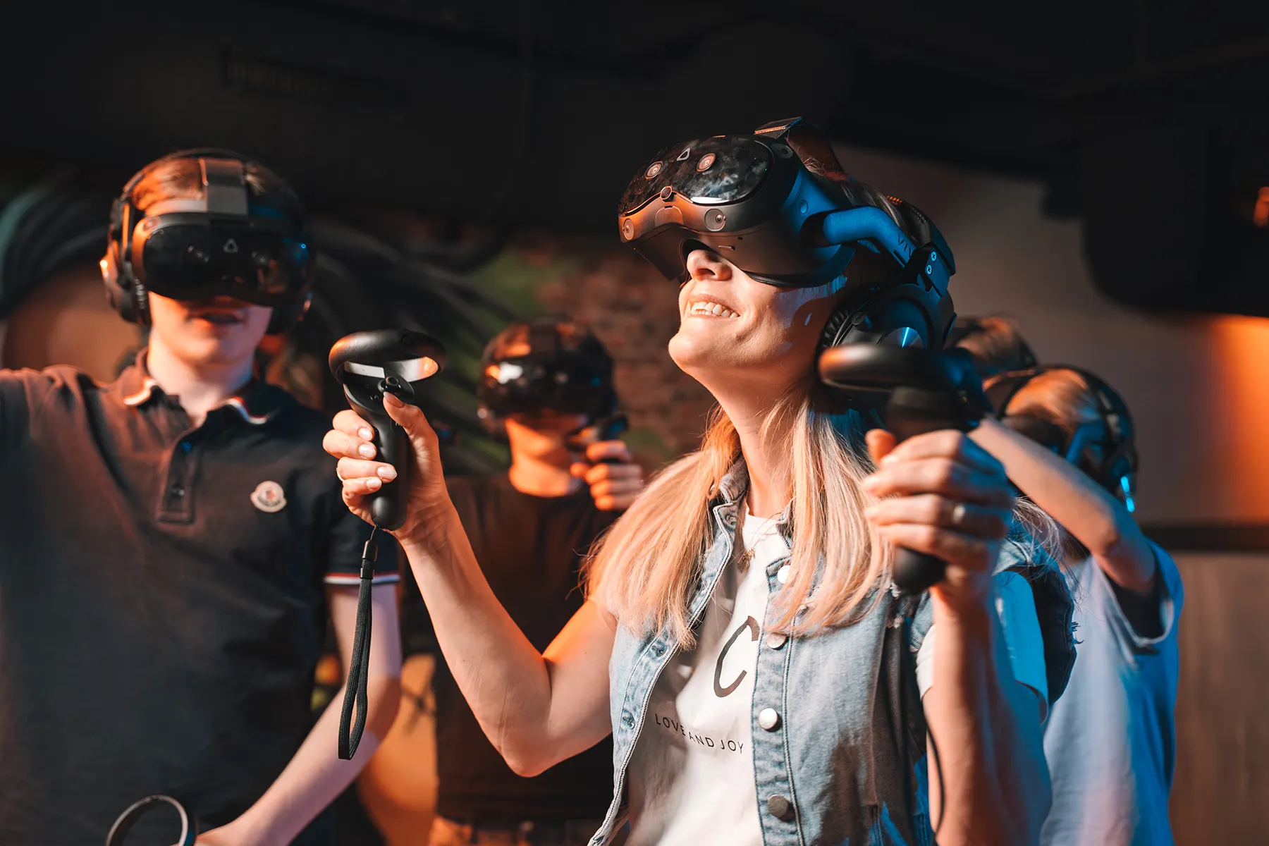 Lachende bezoekers met VR-bril en controllers